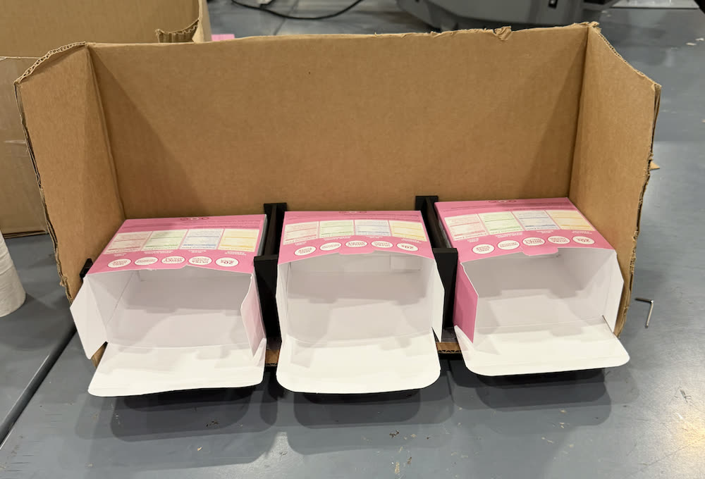 Cardboard fixture holding kitting boxes