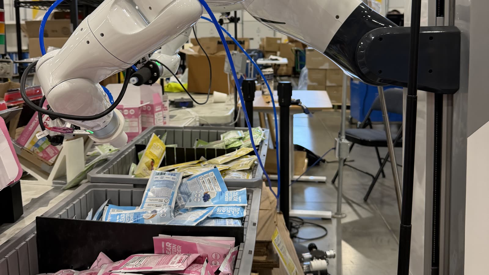 Robot arm picking packets from sorting bins